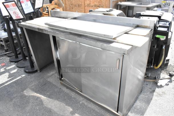 Stainless steel table with sliding doors and under shelf. Heavy-duty, used condition, suitable for kitchen or workshop.