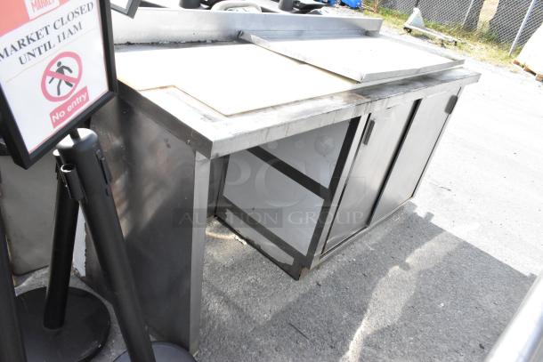 Stainless steel table with doors and under shelf, in fair condition, features two access doors and a durable countertop.