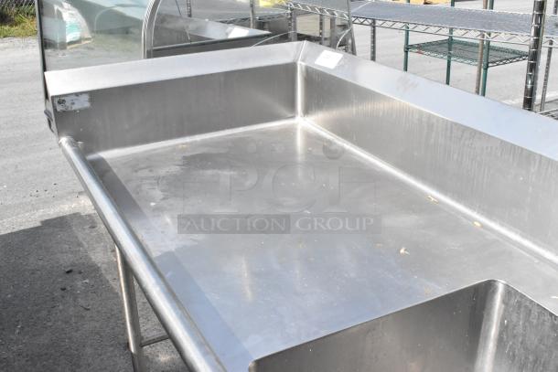 Stainless steel single bay sink with attached faucet and spray nozzle, in good condition, minor surface marks visible.