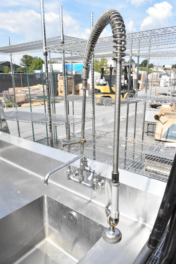 Stainless steel single bay sink with faucet and spray nozzle attachment, featuring durable construction and modern design.