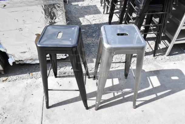 40 Metal Tolix Style Stools; includes black and silver with square seats, handle cutouts, crossbars; used condition.