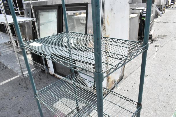 Green 4-tier wire shelving unit, sturdy construction, visible wear, requires dismantling for shipping.