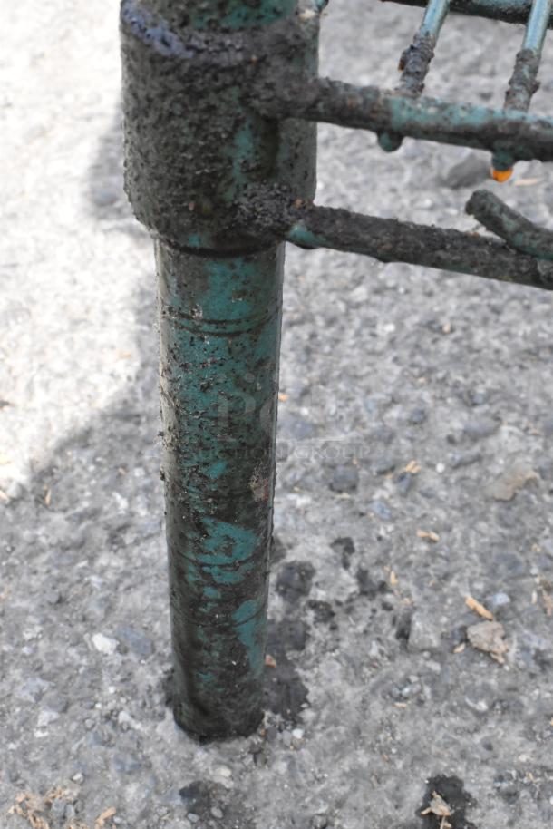 Green finish 4-tier wire shelving unit with visible dirt and wear on metal. Buyer must dismantle; consider freight charges.