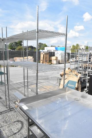 Chrome finish 3 tier wire shelving unit, outdoor setting, requires dismantling for removal. Potential freight charges apply.