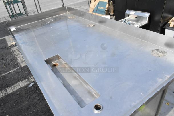 Stainless steel soda station with under shelves, featuring a spacious top, built-in drain holes, and durable construction.