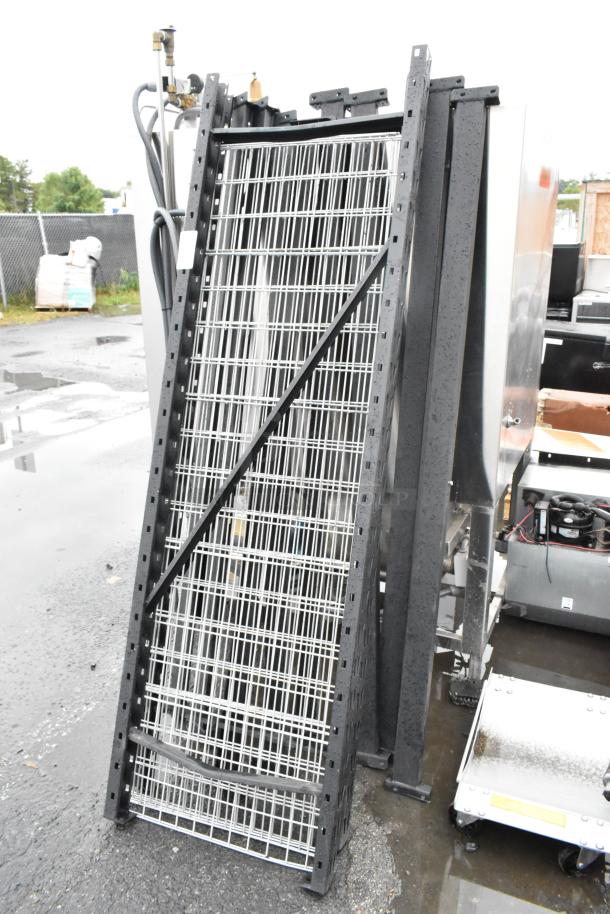 Metal shelving unit components stacked outdoors, black frames with wire shelves. Slight wear visible, suitable for warehouse use.