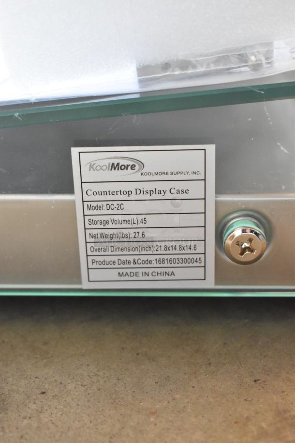KoolMore DC-2C Commercial Bakery Display Case, 1.5 cu. ft., curved glass, rear door, new scratch and dent condition, model label visible.