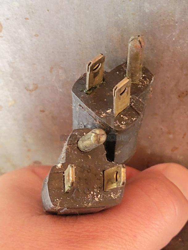 Close-up of a worn electrical plug with visible dirt and cracks, not attached to the Blodgett convection oven model DFG-100/200.