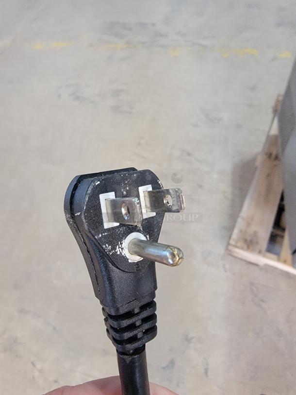 Close-up of a three-prong plug for a Turbo Air refrigerated prep table, ensuring electronic connectivity.