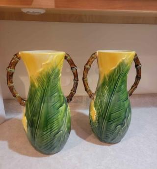 Vintage Majolica pineapple palm frond pitchers, vibrant green/yellow glaze, bamboo-style handles, decorative pair.
