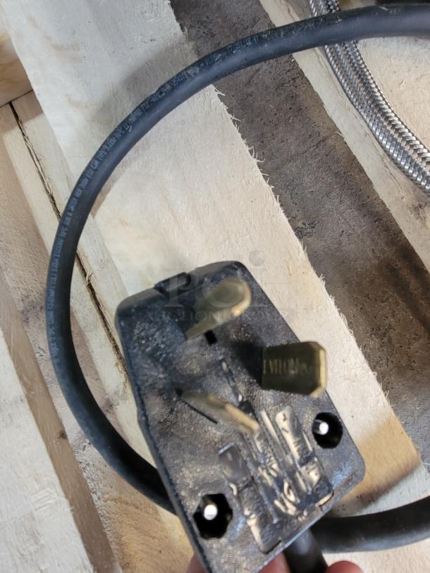 Black power plug and cable for La Spaziale 2-Group Espresso Machine, resting on wooden surface.