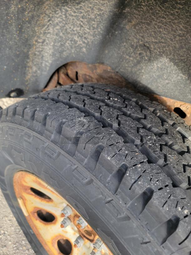 Close-up of a tire on a 2012 Chevy Tahoe 4x4, showing tread detail and rusted wheel rim.