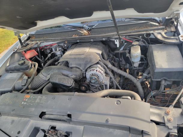 Engine compartment of a 2012 Chevy Tahoe 4x4, showing a well-maintained engine with a new battery and alternator.