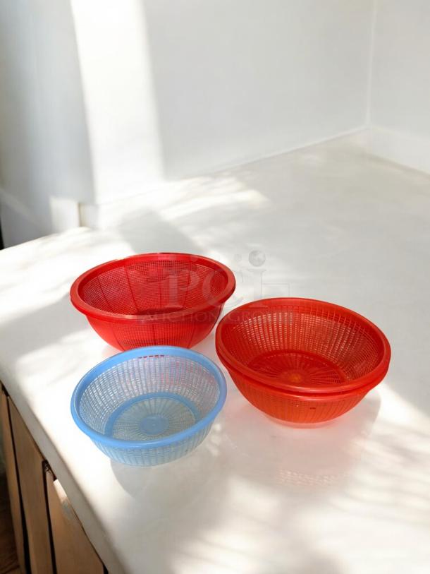 Set of 3 plastic basket strainers in excellent condition. Includes two red and one blue strainer. Fully tested, kitchen-ready.