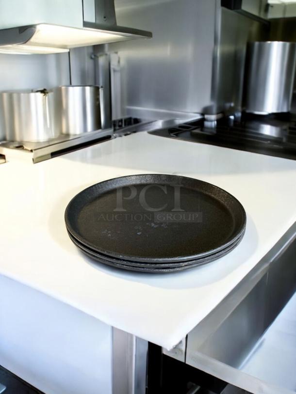 Set of 3 cast iron pizza pans in excellent condition, stacked on a white countertop, fully tested and ready to use.