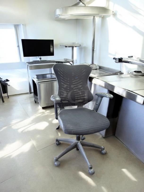 Ergonomic Mesh Back Task Chair in excellent condition, with adjustable armrests and tested functionality, in an office setting.