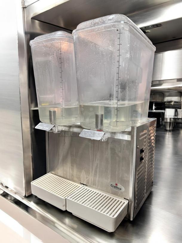 Crathco D25-3 cold beverage dispenser, excellent condition, dual clear containers, Crathco logo visible, stainless steel body.