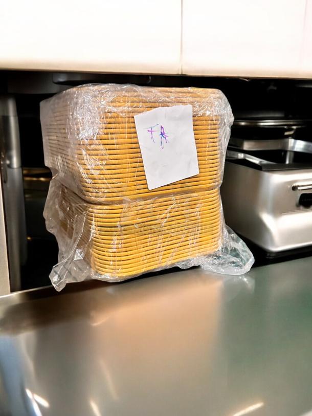 Cambro Camtray® food service trays, model 23-3, in green and yellow, stacked and wrapped in plastic, NSF certified.