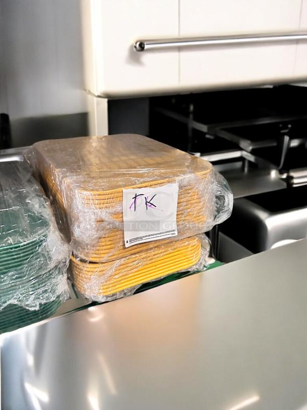 Stack of green and yellow Cambro Camtray® food service trays, NSF certified, model 23-3, packaged, excellent condition.