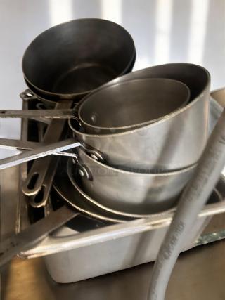 Lot of stainless steel commercial sauce pans with handles in assorted nesting sizes. NSF certified, very good condition.