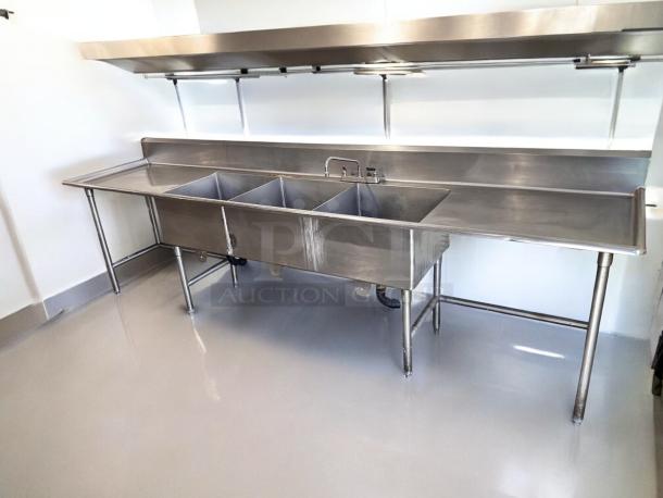 Stainless steel 3-compartment sink with dual drainboards, excellent condition, unbranded commercial model, fully operational.
