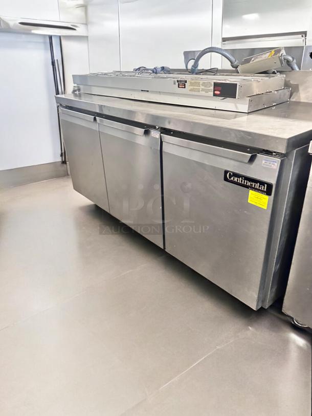 Continental 3-door undercounter refrigerator in excellent condition, stainless steel, fully tested, operational, model label visible.