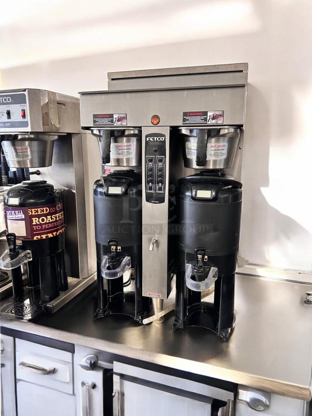 Fetco CBS-2052e Dual Coffee Brewer in excellent condition, fully tested, with dual dispensers, stainless steel finish.