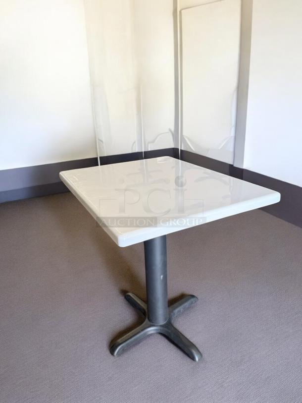 Square dining table in excellent condition, heavy-duty commercial use, sturdy pedestal base, ready for restaurant or café.