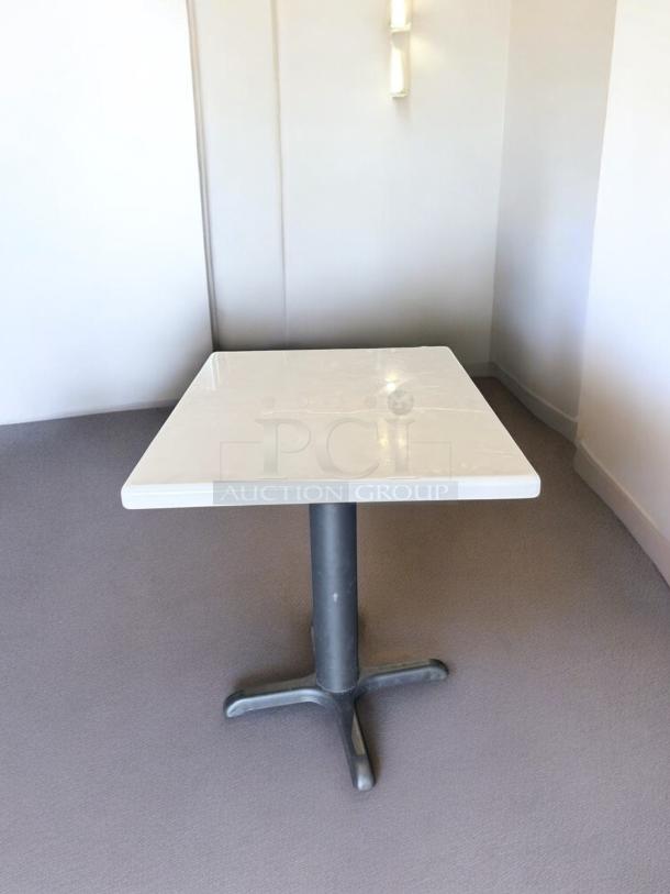 Commercial square dining table, heavy-duty, excellent condition, sturdy black base, cream tabletop, ready for restaurant use.