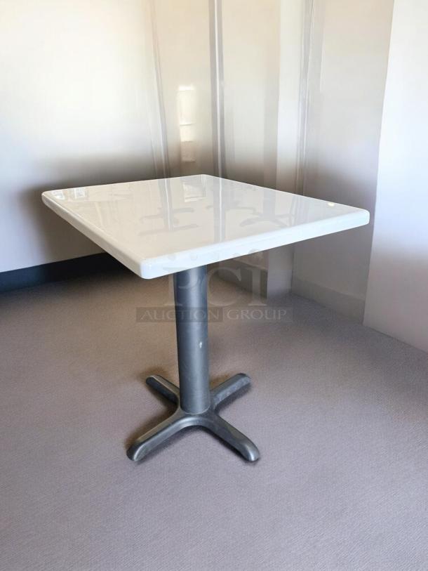 Commercial square dining table, excellent condition, heavy-duty, white tabletop with black pedestal base, ready for use.