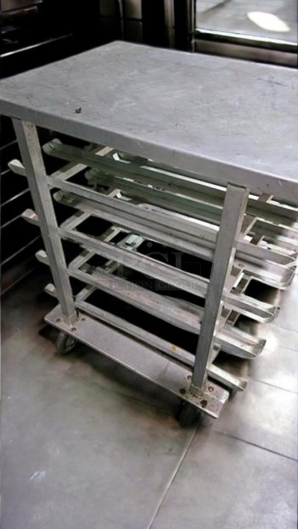 Stainless steel mobile bun/sheet pan rack with solid top work table. Excellent condition, fully tested, eight slots, on wheels.