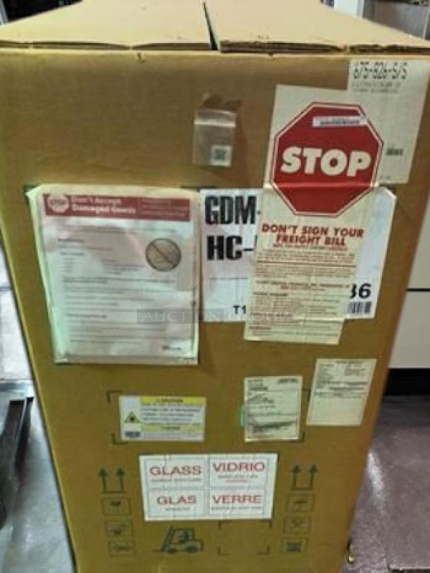 Brand new True GDM-HC double glass door merchandiser refrigerator, factory sealed in crate, visible shipping labels and instructions.