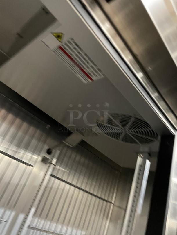 True T-49F-HC commercial stainless steel 2-door reach-in freezer with poly-coated wired racks, 115V, on casters.