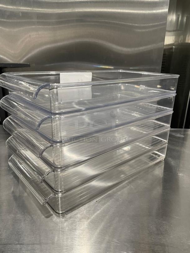 New lot of commercial clear polycarbonate rectangular food pans, stackable, mint condition, ideal for kitchen use.