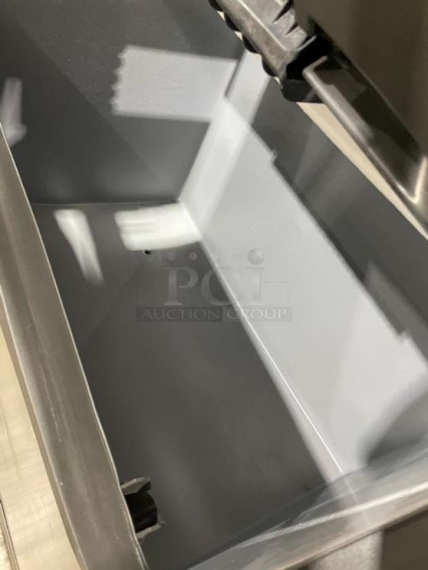 Manitowoc stainless steel ice machine bin interior, model ID0892N261. Clean and spacious with visible ice chute.