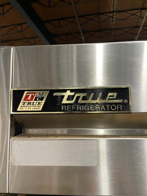 True T-49 commercial stainless steel 2-door refrigerator, with poly-coated racks, on casters. Model tag visible.
