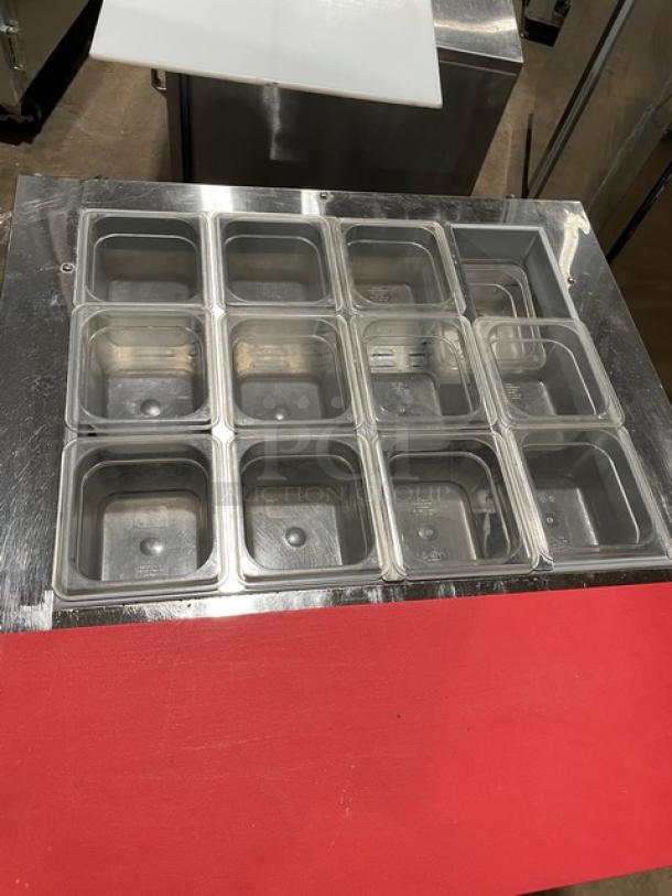 Continental SW3212M refrigerated prep table with stainless steel worktop, red cutting board, clear food pans, and wire rack.