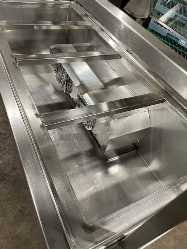 Atlas Metal WCMBT4 stainless steel refrigerated 4-well cold food/salad bar with sneeze guard, tray slide, and storage below.