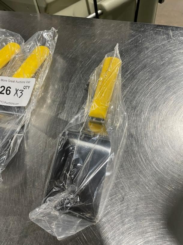 Brand new Dexter Russell Sani-Safe S286-4 hamburger turner, 4"x3", stainless steel, yellow grip, wrapped in plastic packaging.