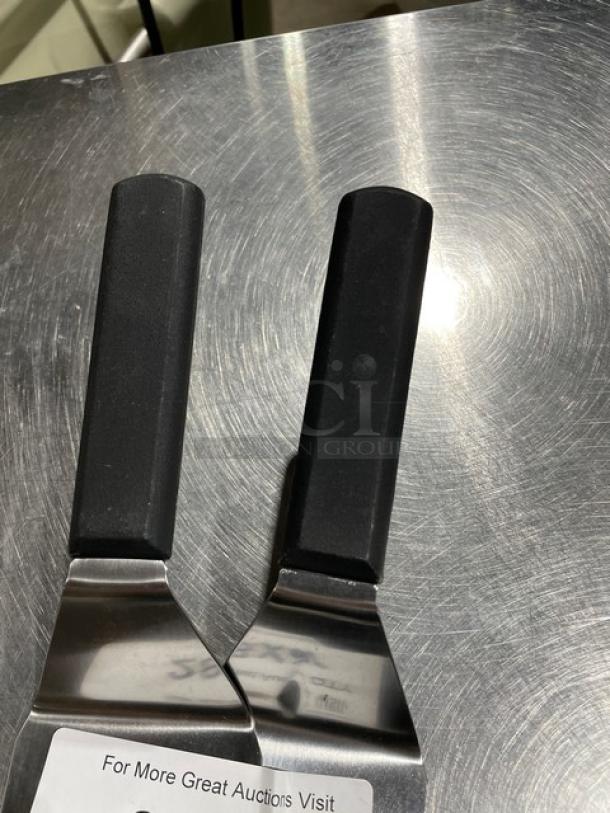 Brand new Dexter Russell Model P94857 stainless steel perforated cake turner, 8"x3", with black grip handle.