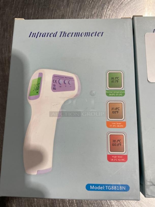 Brand new infrared non-contact forehead thermometer, model TG8818N, in box. Features temperature range indicators.