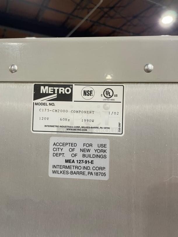 Metro FlavorView Series heated cabinet, model C175-CM2000, 120V, with pan holding rack, on casters. Labels show compliance info.