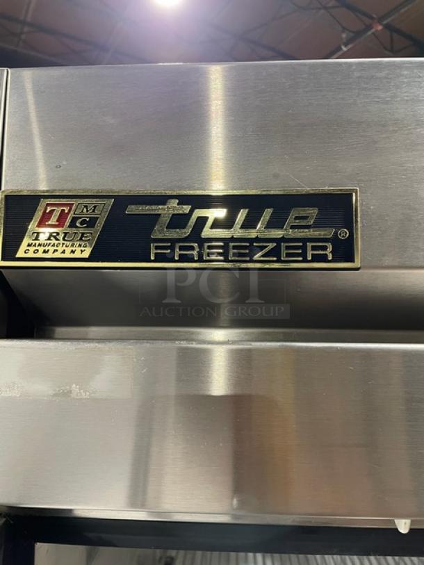 True T-49F commercial stainless steel 2-door reach-in freezer, features poly-coated wired racks, label showing model and brand.