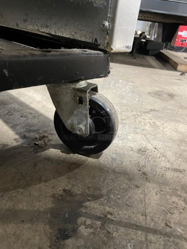 Alt text: Close-up of caster wheel on True T49F commercial stainless steel freezer, model: T-49F, SN: 1-4032036.