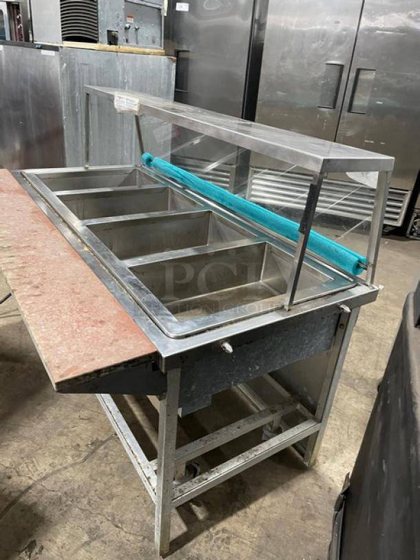 Atlas Metal stainless steel 4-well hot food steamtable with serve-over sneeze guard, tray slide, 208V 1 phase, on casters.