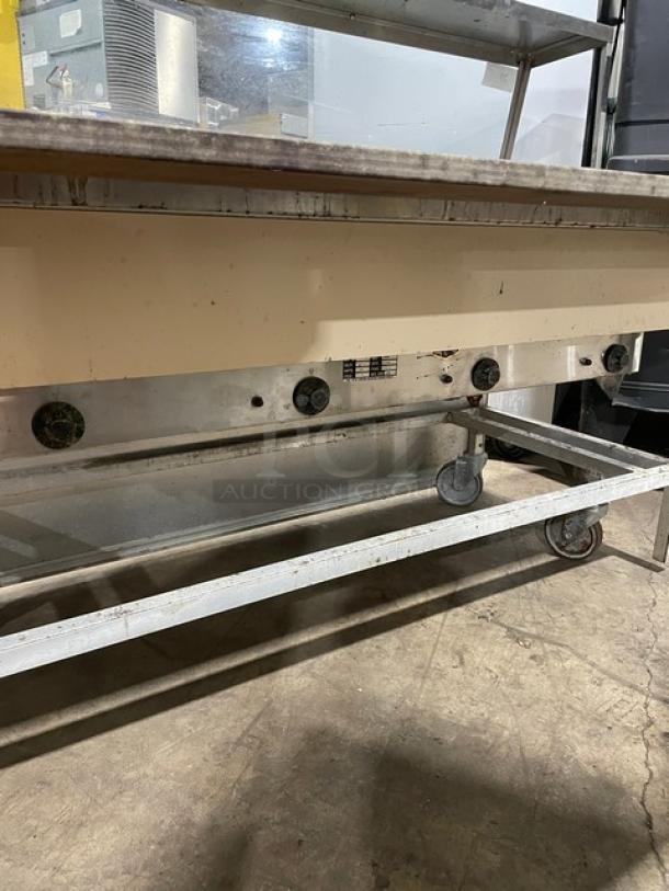 Atlas Metal commercial stainless steel 4-well steamtable with sneeze guard, tray slide, and casters, 208V, 1 phase.
