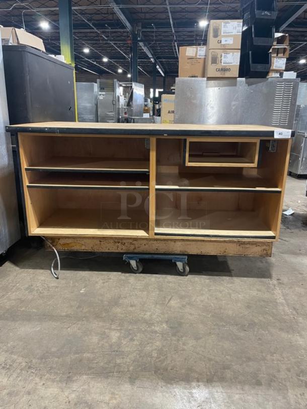 Custom commercial wooden cabinet base with multi-level shelving, enclosed style, on wheels, used condition.