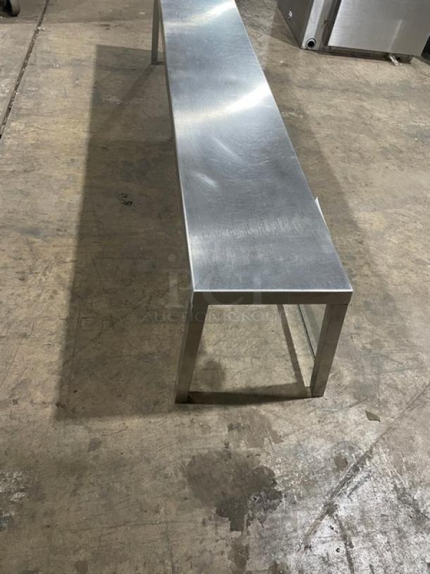 Commercial stainless steel serve over sneeze guard, rectangular, sturdy design, in used condition, industrial setting.