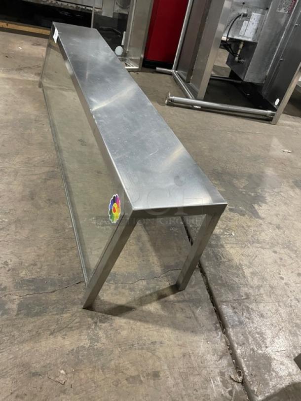 Stainless steel serve over sneeze guard, commercial-grade, glass panel, durable construction, used condition, colorful sticker.