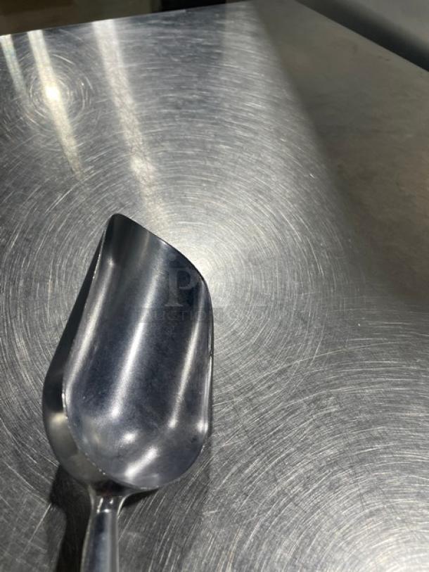 New commercial cast aluminum 5 oz. handheld scoop, model ASC-05, shown on a metallic surface. Pristine condition.